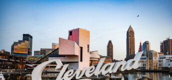 In Ohio the Cleveland script sign is placed in front of the cityscape with the Rock and Roll Hall of Fame building.