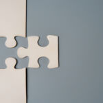 Credit manager Serone launches buyout secondaries strategy Two puzzle pieces connecting, one white and one grey, on a contrasting background